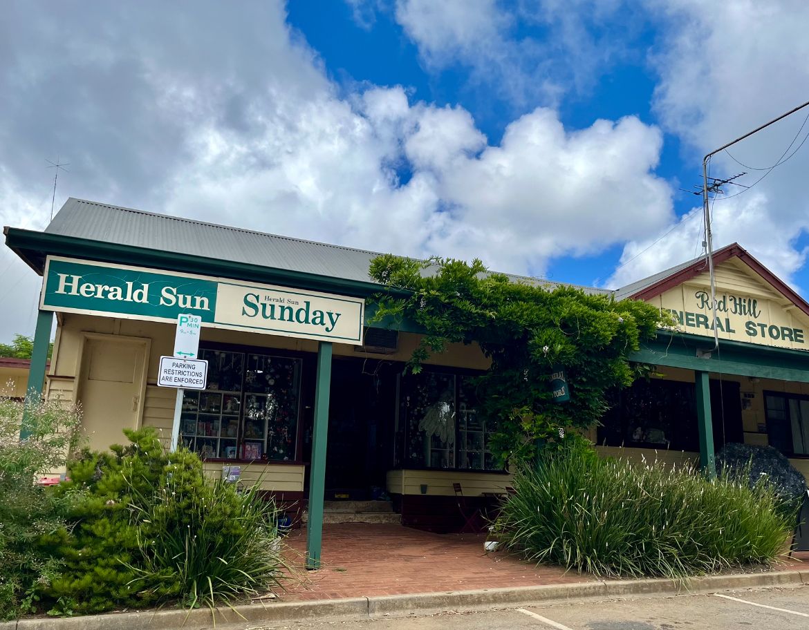 Red Hill General Store heritage building exterior with green awning, climbing vine, and blue sky