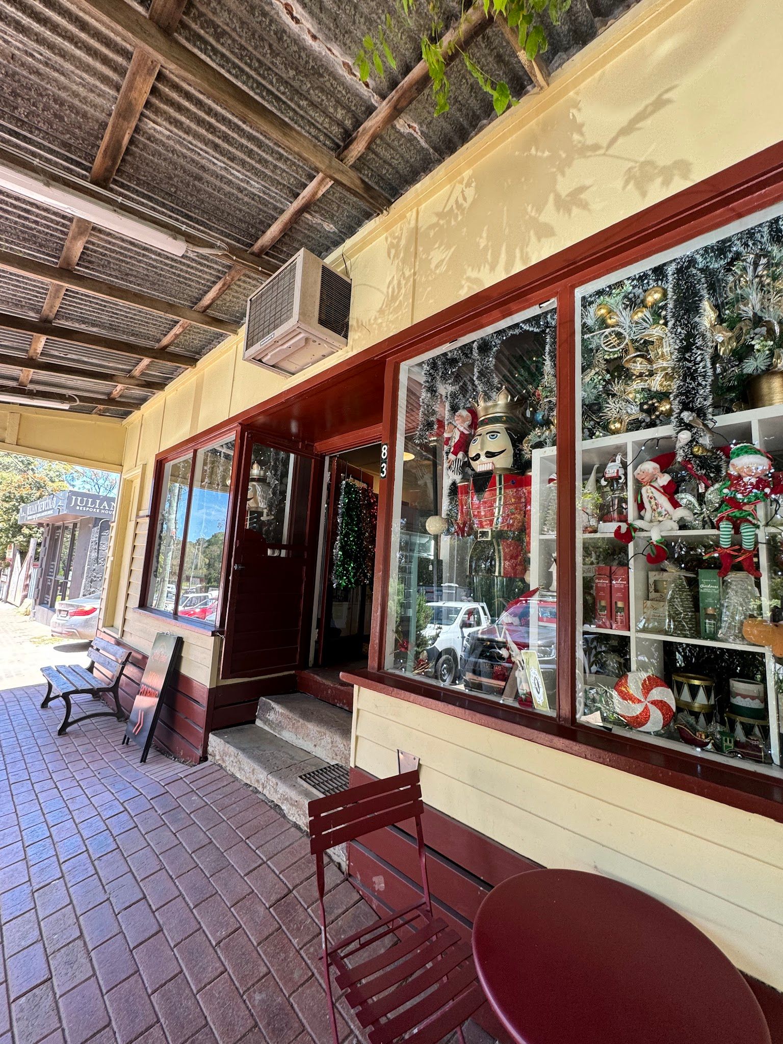 Red Hill General Store verandah with red outdoor chairs, timber posts, and shop window display