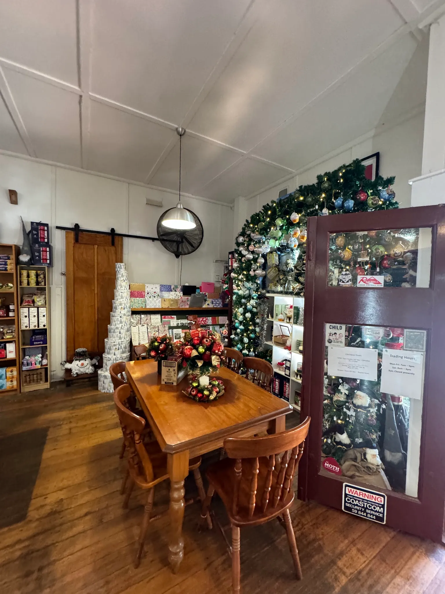 Red Hill General Store interior dining area with timber table, chairs, pendant light, and barn sliding door